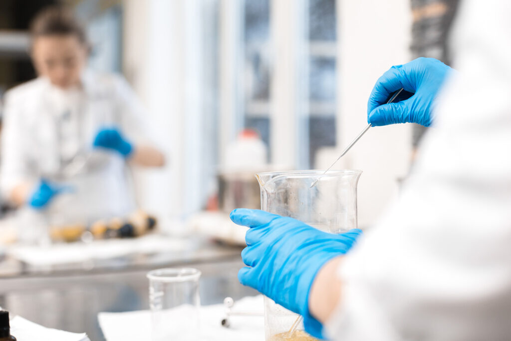 Stock image of scientist working in the lab pipetting solution into a beaker